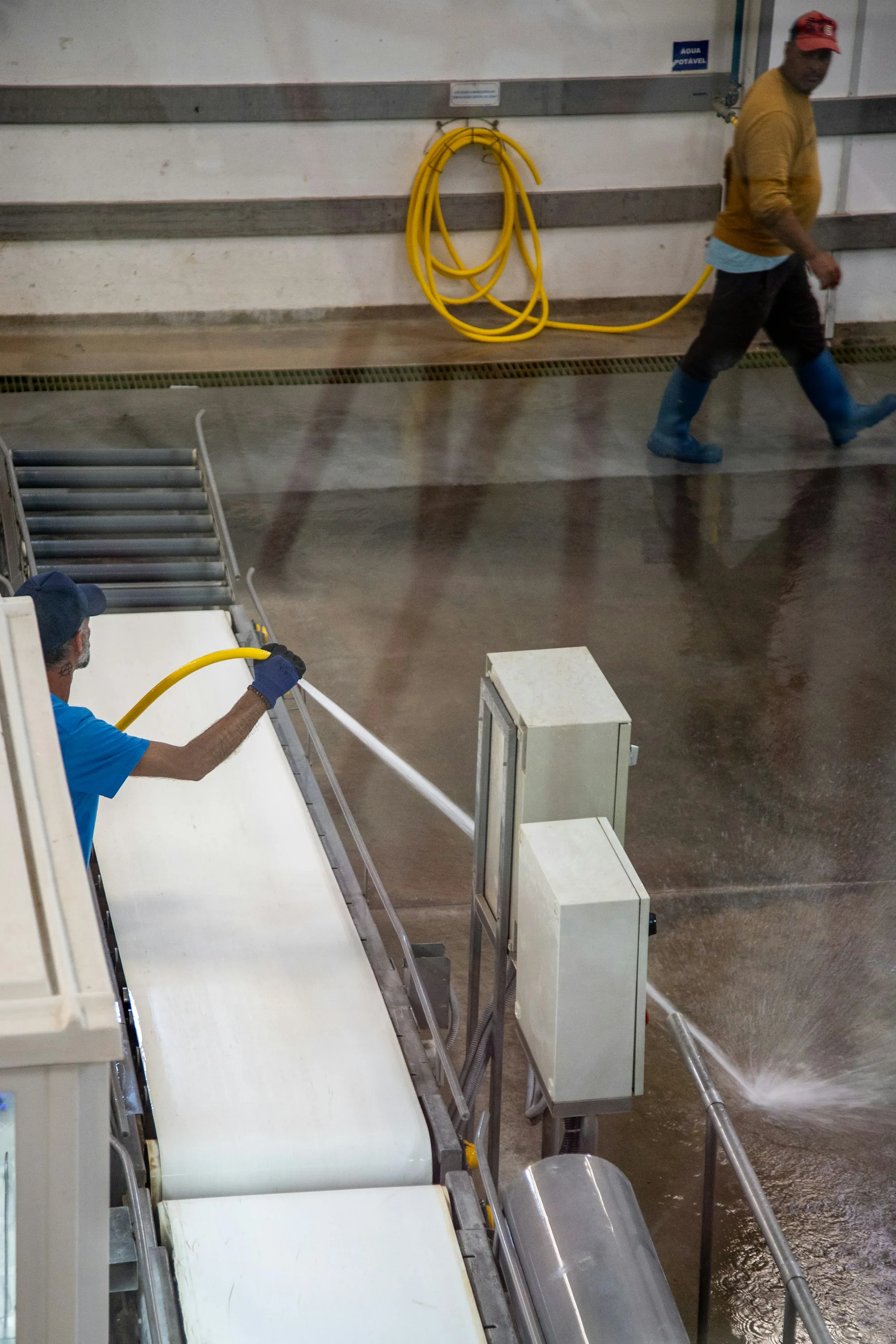 Worker cleaning the steps of a stairwell with a hose